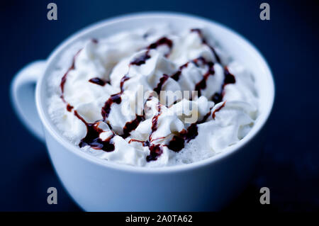 Tasse heißen Kakao oder mokka Kaffee closeup in einem großen weißen Schale verwischt. Frische Sahne beträufelt mit Schokolade Sirup und dunklen Hintergrund Detaillierte Stockfoto