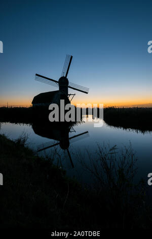 Silhouette einer holländischen Windmühle gegen die Dämmerung Himmel Stockfoto