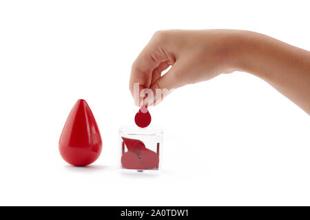 Blutspender. Die Hand Tropfen Blut in das Feld als Spende auf weißem Hintergrund. Konzept Blut spenden Leben retten. Stockfoto