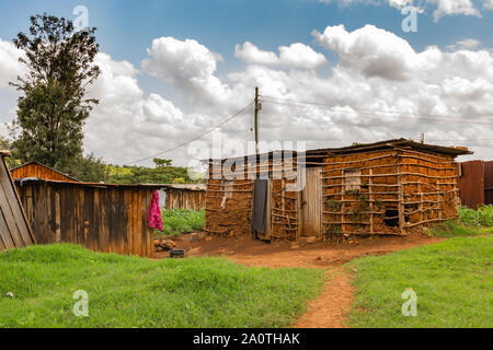 Farbe Landschaft Foto von sparse behelfsmäßigen Wohnungen inmitten üppiger Vegetation, in Kangaita Dorf, Meru, Kenia. Stockfoto