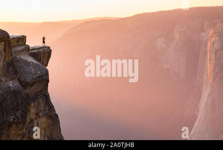 Ein Wanderer steht am Rand einer Klippe an Taft Point mit Blick auf El Capitan im Yosemite National Park, Kalifornien. Stockfoto