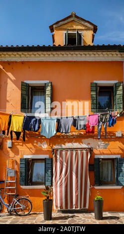 Waschen heraus hängen aus den Fenstern der Bunte Häuser auf der Insel Burano, Italien zu trocknen Stockfoto
