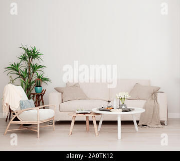 Mock up Wand mit beige weiß Sofa, zwei Tische, ein Stuhl in der modernen Interieur Hintergrund, Wohnzimmer mit großem Fenster und ein kühler, skandinavischen Styl Stockfoto