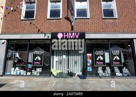 Allgemeine Ansicht eines geschlossenen HMV Store mit Wohnungslosen Material in der Tür in Chichester, West Sussex, UK. Stockfoto