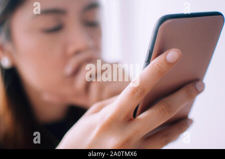 Ein depressiver junge Frau mit einem Mobiltelefon Stockfoto