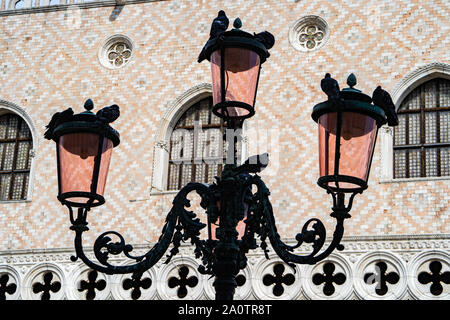 Reich verzierte Lampe Beiträge mit Tauben sitzen auf Sie vor dem Dogenpalast, Markusplatz, Venedig, Italien Stockfoto