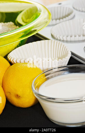 Zutaten für die Herstellung hausgemachter lemon Muffins oder Cupcakes benötigt. Diese gehören Milch, Zitronen, Teig, eine Schüssel und Pappbecher und einen Muffin Backen Stockfoto