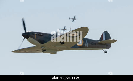 Duxford, Cambridgeshire, Großbritannien. 21. September 2019. 1940 themenorientierte Wochenende fliegen am IWM Duxford mit historischen WW2 Flugzeug und einen massierten Flug von 15 Spitfires, zum Gedenken an den 50. Jahrestag der Film "Schlacht um England". Bild: RAF Spitfire mit zwei ME 109 (Buchons) angreifenden im Hintergrund. Credit: Malcolm Park/Alamy Leben Nachrichten. Stockfoto