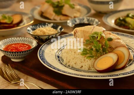 Hainanese Chicken Rice. Duftreis in Hühnerbrühe gekocht; Dann garniert mit pochiertem Huhn und Ei. Stockfoto