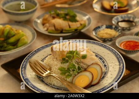 Hainanese Chicken Rice. Duftreis in Hühnerbrühe gekocht; Dann garniert mit pochiertem Huhn und Ei. Stockfoto