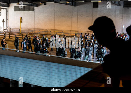 Hongkong, China. 21 Sep, 2019. Eine Demonstrantin sieht auf die Bereitschaftspolizei in der Nähe einer MTR exit während der Demonstration stationiert. Ein anti-government März friedlich begann, bevor die Demonstranten mit der Polizei später am Tag zusammengestoßen. Polizei mit Pfefferspray und Gummigeschossen während Demonstranten schleuderten Steine und Benzinbomben. Auch andere Demonstranten hielt eine kleine Gedenkstätte an einer MTR-Station, die von Polizisten des vorhergehenden Monats gestürmt worden war. Credit: SOPA Images Limited/Alamy leben Nachrichten Stockfoto