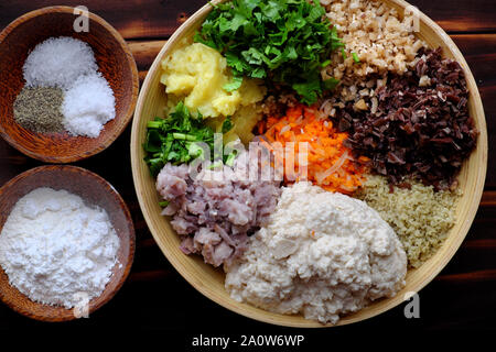 Ansicht von oben vorbereiten Lebensmittelzutat für gebratene vegan Tofu pie, Rohstoffe aus Tofu, Pilzen, Karotten, grüne Bohne, Taro, Koriander, gehackt Gemüse Stockfoto