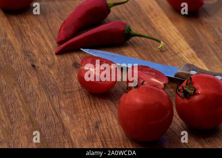 Schöne rote Paprika oder Chili auf Holz- oder schneidebrett Hintergrund, frische Chilis vom Bauernhof und Sonnenschein, Red Hot Chili Pepper Stockfoto