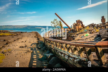 Schönen Meereslandschaft mit einem halb zerstörten altes Fischerboot am Strand und der Klang der Mull im Hintergrund. Isle of Mull, Schottland, August 2019. Stockfoto