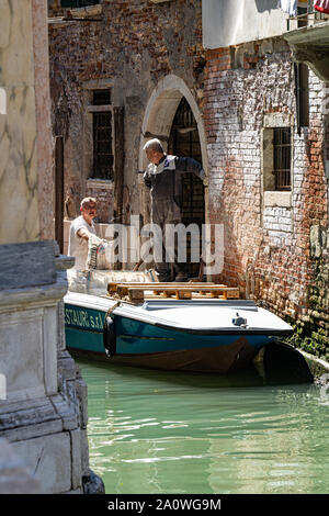 Arbeiter mit den Kanälen von Venedig wie Transport, Baustoffe Stockfoto