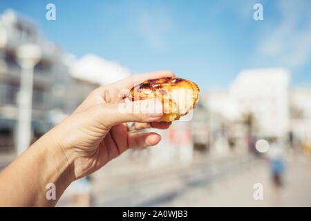 Traditionelle portugiesische Desserts in der Hand der Frau. Pastel de Nata. Stockfoto