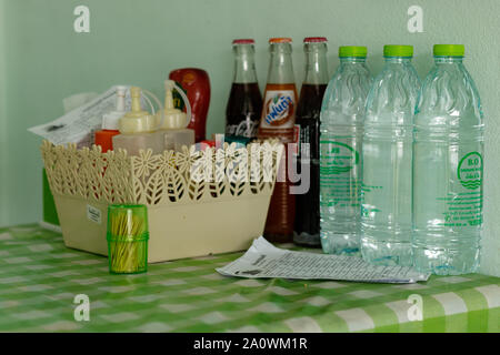 Phuket/Thailand - 12. Juni 2018: Plastikflaschen mit Kunststoff Tischdecke in ein billiges Restaurant in Phuket Thailand Stockfoto