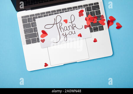 Blick von oben auf die Laptop und Karte mit vielen Dank, dass sie Schrift und Papier roten Herzen auf blauem Hintergrund Stockfoto