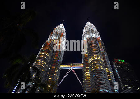 Kuala Lumpur, Malaysia, 08.14.2019: Erstaunlich bunten Petronas Twin Towers mit Double Decker skybridge beleuchtet mit Gelb, Rot, Blau und Weiß Stockfoto