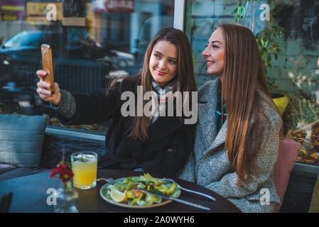 Zwei hübsche Frau im Cafe die selfie Met Stockfoto