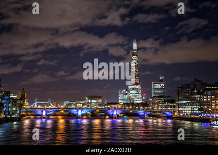 Blick entlang der Themse aus der Millennium Bridge, die beleuchtete Skyline von London bei Nacht, mit modernen Bürogebäuden, die Southwark Bridge i Stockfoto