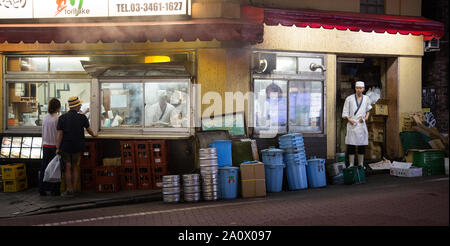 Tokyo, Japan - 21. Juni 2016: Zurück Street Restaurant mit Kunden bestellen bei einem Takeaway Fenster. Köche in Uniform sind die Zubereitung von Speisen in der Küche Stockfoto