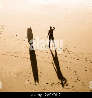 Blick von oben auf ein Surfer am Strand die Wellen prüfen. Stockfoto