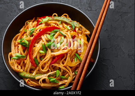 Vegetarische Schezwan Nudeln oder Gemüse Hakka Nudeln oder Chow Mein in schwarz Schüssel am dunklen Hintergrund. Schezwan Nudeln ist indo-chinesischen Küche heiß Dis Stockfoto