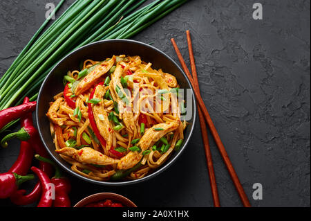 Huhn Schezwan Nudeln oder Hakka oder Chow Mein in schwarz Schüssel am dunklen Hintergrund. Schezwan Nudeln ist indo-chinesischen Küche warmes Gericht mit udon Nudeln, Stockfoto