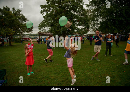 Des Moines, USA. 21 Sep, 2019. Ein Mädchen in die Luft mit einem Ballon springt während der Polk County Steak braten am Wasser funktioniert Park in Des Moines, Iowa. Das Event zog in der 17 Kandidaten für die demokratische Nominierung für das Amt des Präsidenten der Vereinigten Staaten. Die Iowa Kaukasus sind Montag, 3. Februar 2020 und obwohl keine primäre wird schmaler hinunter das Feld der Kandidaten für das Amt des Präsidenten, bevor die erste Wahl im Bundesstaat New Hampshire. Credit: SOPA Images Limited/Alamy leben Nachrichten Stockfoto