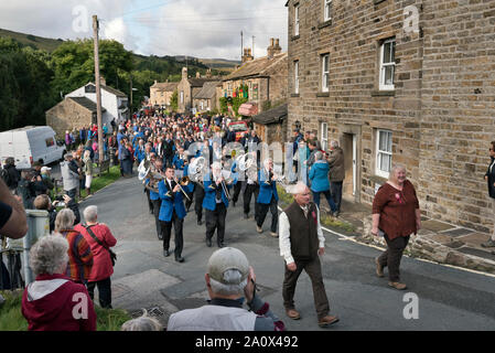 Muker Silber Band führen die Prozession durch das Dorf, um die Muker zeigen, Swaledale, North Yorkshire, September 2019 zu öffnen. Stockfoto