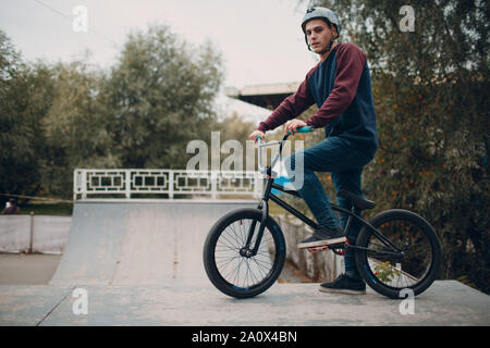 Professionelle junge männliche Sportler Radfahrer mit bmx Fahrrad an Skatepark Stockfoto
