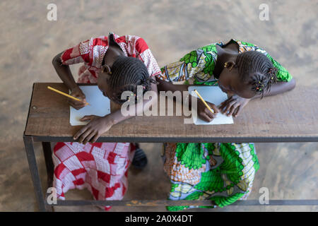 Blick von oben auf die zwei wunderschönen afrikanischen Mädchen Schreiben in der Schule Stockfoto