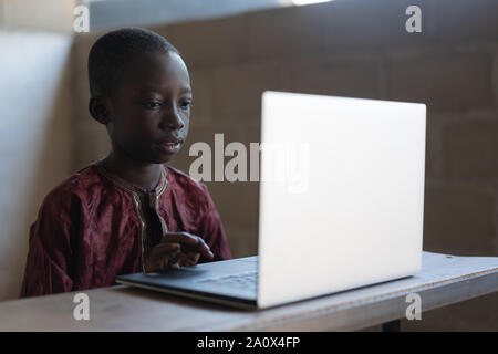 Technologie für zukünftige Afrika, schwarzen Jungen lernen mit Laptop Stockfoto