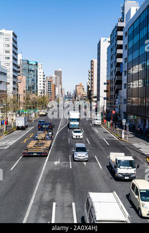 Die route, Straße durch Sugamo Stadt in Tokio, Japan. Blick entlang der Straße beschäftigt mit Verkehr von Overhead Bridge. Gebäude auf beiden Seiten. Stockfoto