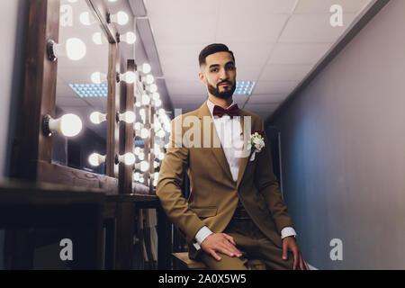 Schöne starke stilvolle bärtigen Bräutigam in der Nähe von Spiegel posieren. Stockfoto