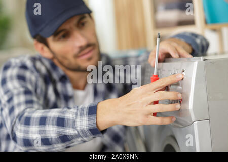 Klempner zur Festsetzung der Waschmaschine auf weißem Hintergrund Stockfoto
