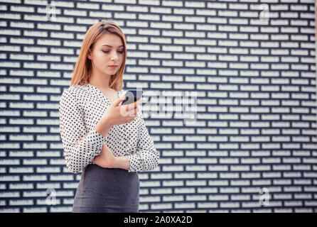 Porträt der schönen Ernsthafte junge Frau beim Surfen im Internet am Handy, am Bildschirm mit konzentrierter Ausdruck suchen, E-Mails, Mädchen wea Stockfoto