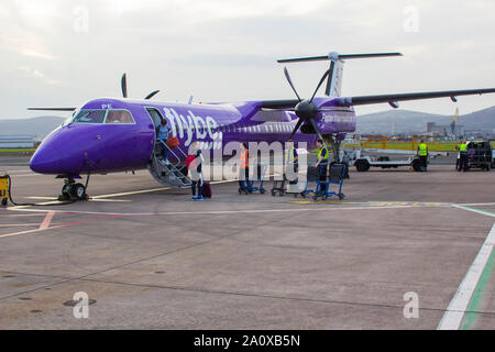 21. September 2019 eine FlyBe Dash 8 Verkehrsflugzeug mit Gepäck und Passagiere Handler auf dem Vorfeld des George Best City Airport in Belfast, Nordirland Stockfoto