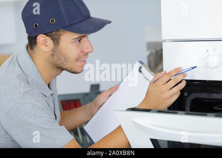 Junge männliche Techniker prüfen Backofen Stockfoto