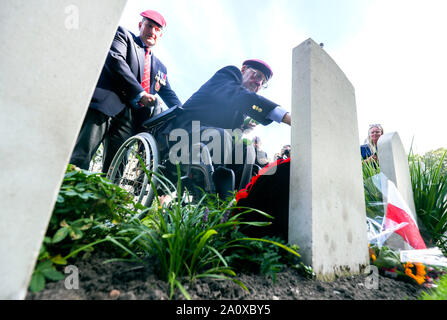 Sandy Cortmann berührt den Grabstein seines Freundes Gordon Matthews nach einer Trauerfeier in den Niederlanden, während der Gedenkfeiern zum 75. Jahrestag der militärischen Operation in Arnheim, codenamed Operation Market Garden, bekannt aus dem Film einen Schritt zu weit. Stockfoto