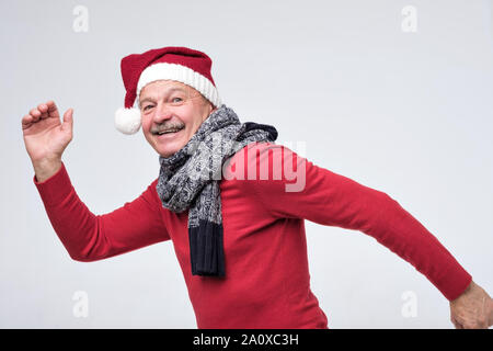 Hispanic reifer Mann in Rot Mütze läuft schnell. Von der Seite. Studio shot Stockfoto