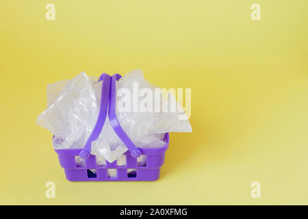 Polyäthylenbeutel im Warenkorb auf gelben Hintergrund. Stockfoto