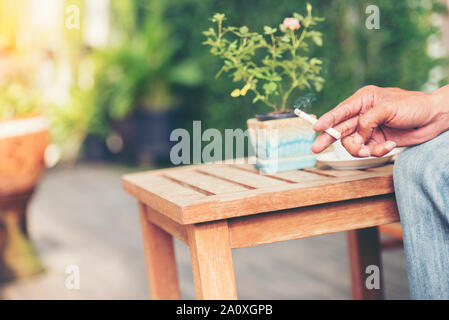 Mann Rauchen einer Zigarette. Rauch ausbreiten. Stockfoto