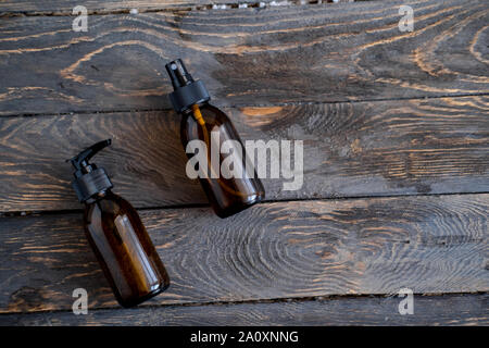 Dunkel Braun Glas Kosmetik Flaschen auf Holztisch und Overhead. Schönheit Produkte Konzept Stockfoto