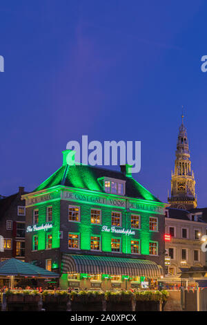 Ein Abend in Amsterdam, mit dem Blick auf die Heuschrecke und die Oude Kerk (Alte Kirche) im Hintergrund, das älteste Gebäude in Amsterdam. Stockfoto