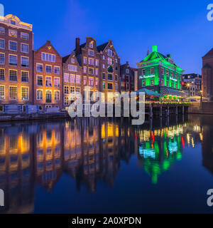 Ein Abend in Amsterdam, mit dem Blick auf die Heuschrecke und die Oude Kerk (Alte Kirche) im Hintergrund, das älteste Gebäude in Amsterdam. Stockfoto