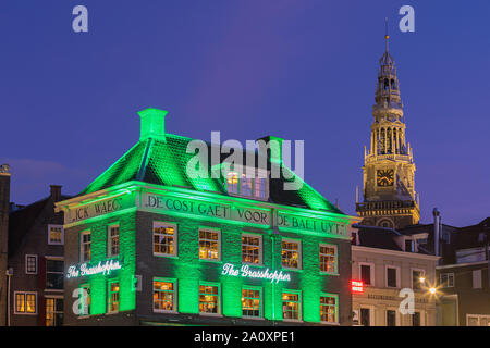 Ein Abend in Amsterdam, mit dem Blick auf die Heuschrecke und die Oude Kerk (Alte Kirche) im Hintergrund, das älteste Gebäude in Amsterdam. Stockfoto