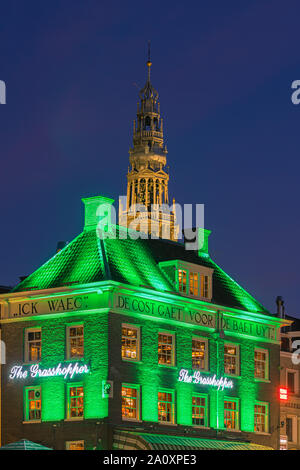 Ein Abend in Amsterdam, mit dem Blick auf die Heuschrecke und die Oude Kerk (Alte Kirche) im Hintergrund, das älteste Gebäude in Amsterdam. Stockfoto