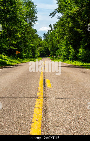 Den Blick von der Mittellinie einer leeren Landstraße. Stockfoto